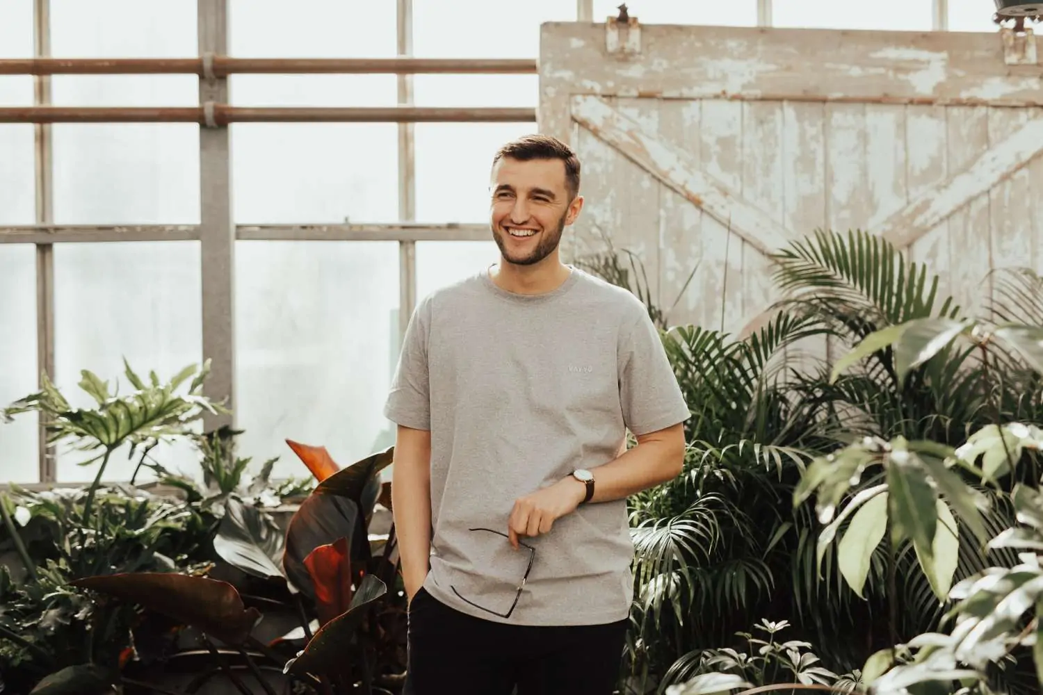 Homme souriant en t-shirt clair, dans un atelier