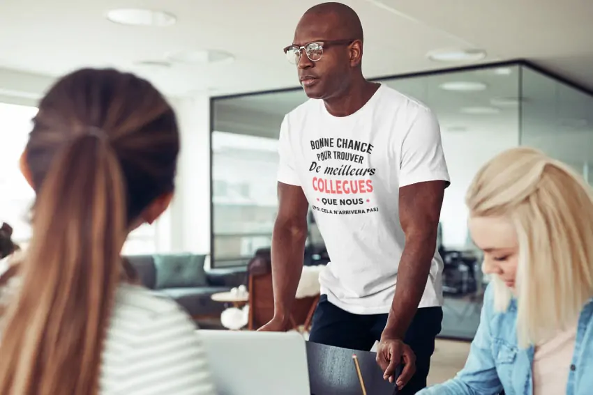 Collègues au bureau, l'un porte un t-shirt de départ
